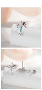 Macro view of cross stud earring with marquise blue zircon and silver metal detailing