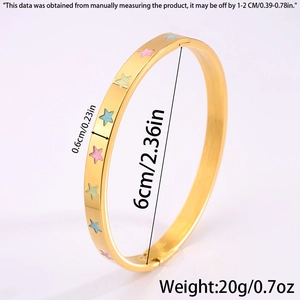 Macro shot showing dimensions of gold star pattern titanium bangle with enamel detail