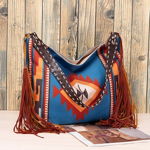 Detail of tribal pattern hobo bag featuring ethnic embroidery and leather fringe
