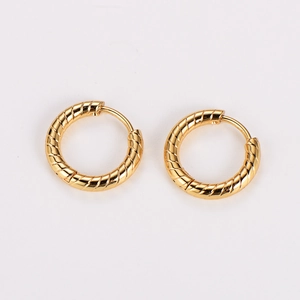 Detailed view of golden hoop earrings featuring a vintage textured twisted metal pattern