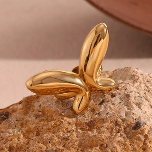 Gros plan détaillé d'une bague papillon plaquée or 18 carats sur une surface de pierre