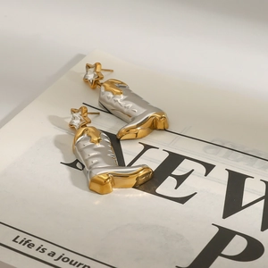 Detailed close-up of cowboy boot earrings with gold and silver tones and star studs