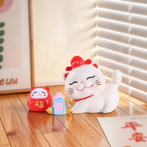Détails des figurines chat de fortune et sac de bénédiction sur un bureau en bois ensoleillé