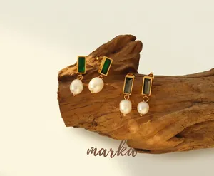 Detail of gold titanium earrings with green zircon and natural freshwater baroque pearls