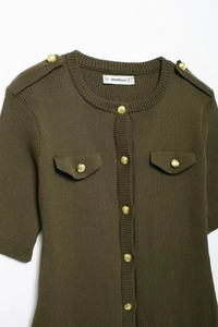 Detail of army green ribbed knit dress with gold buttons and decorative flap pockets