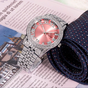 Detailed close-up of iced-out silver watch with pink dial and Roman numerals on tie