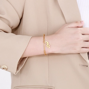 Women's gold plated stainless steel open bangle with moon and star charms worn with suit