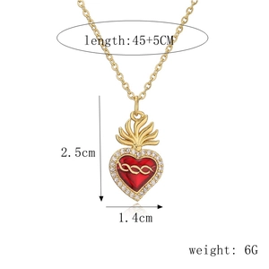 Dettaglio della collana con ciondolo a cuore sacro dorato con smalto rosso e zirconi