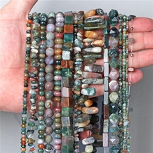 Close-up of various natural stone beads in hand showing detailed textures and sizes