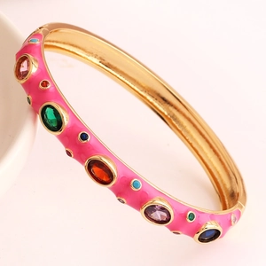 Detailed side view of pink enamel bangle with multicolor zircons and gold plating