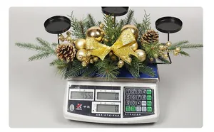 Christmas table centerpiece with golden ornaments and pinecones displayed on a weight scale