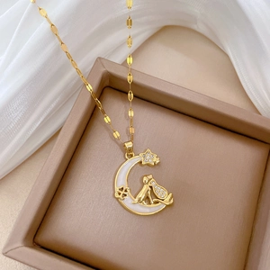 Detailed close-up of golden moon and cat pendant necklace on premium silk jewelry box