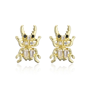 Macro detail of gold-plated stag beetle earrings with clear and black cubic zirconia