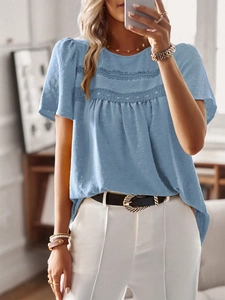 Detailed macro view of blue round neck blouse with lace trim and textured polka dot fabric
