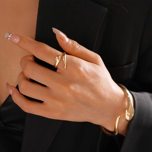 Close-up of golden liquid metal snake-style open ring and bracelet set on wrist