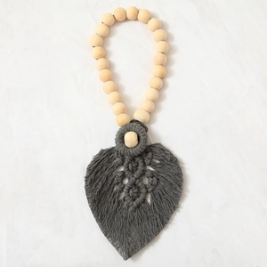 Close-up of heart-shaped dark grey cotton rope weaving with wooden beads detail