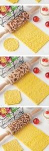 Close-up of wooden rolling pins with engraved reindeer and snowflake Christmas patterns