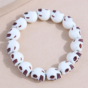Fashionable elastic bracelet featuring detailed white skull beads with dark accents