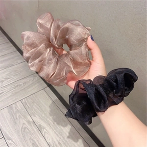 Detail of champagne gold and black pearlescent organza scrunchies with soft silk texture