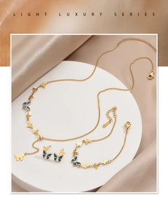 Detailed set of gold butterfly jewelry with blue enamel on elegant silk background