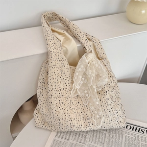Detail of floral canvas tote bag featuring an elegant lace hollow bow decoration