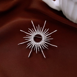 Macro detail of silver sunburst starburst brooch with micro-pave white cubic zirconia