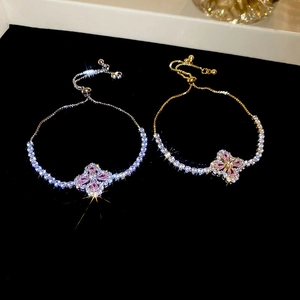 Détail de bracelets fleurs réglables avec pierres roses et finition en argent poli