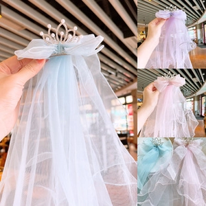 Detail of glitter crown veil hair clips in blue, purple, and pink colors with pearls