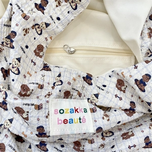 Dettaglio della borsa seersucker a quadri blu con stampe di cuccioli e cerniera interna