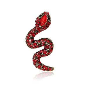 Vintage gold snake brooch with red rhinestones and crystals on a white background