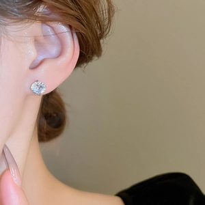 Close-up of sparkling cubic zirconia stud earring worn on model's earlobe