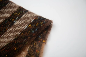 Detailed macro view of the brown herringbone weave pattern with multi-color yarn specks