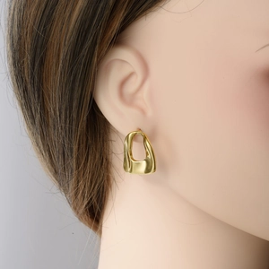 Fashionable gold 304 stainless steel hollow oval earrings worn by a model in a side view