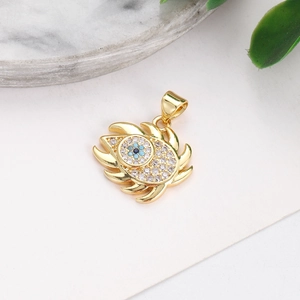 Macro shot of gold-plated evil eye heart pendant with blue and clear crystals