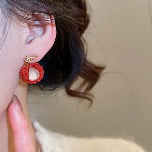 Close-up detail of a sweet resin apple earring with zircon embellishment on ear.
