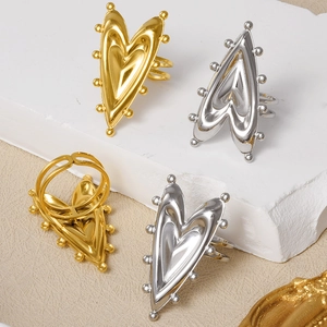 Detail of gold and silver open heart rings with metal bead edges on stone props