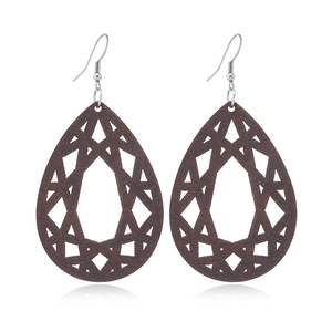 Close-up of brown wooden teardrop earrings with geometric cutout and silver hooks