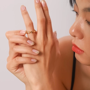 Close-up of 18K gold wave ring with leaf diamonds on a model finger for elegant jewelry style