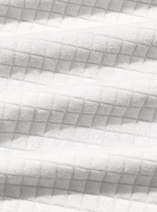 Close-up of white waffle texture fabric showing detailed quilted pattern and material