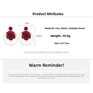 Detailed specs of wine red fabric rose earrings with pearls and golden rings
