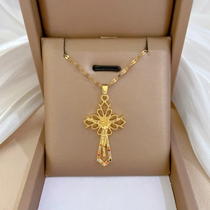 Macro detail of gold cross pendant with colorful gemstones and crucifix in jewelry box