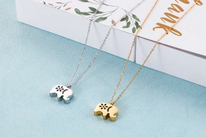 Detail view of elephant pendant necklaces in gold and silver finish with hollow patterns
