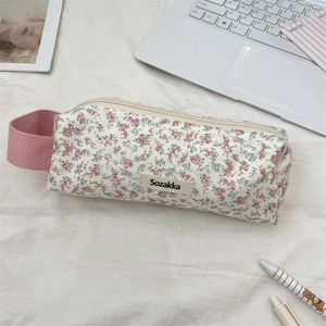 Close-up of floral fabric pencil case with portable handle on a desk setting