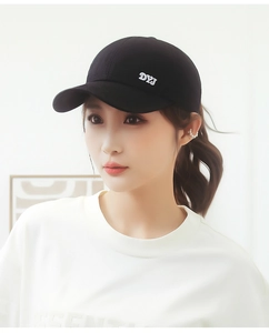 Detail view of the black cotton baseball cap with DYJ embroidery on model side profile