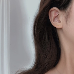Minimalist gold bar threader earrings with long tassel chains shown on model
