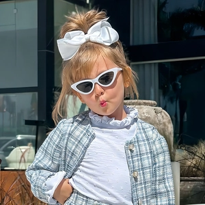 Fashionable blue cat-eye triangle sunglasses for kids paired with a chic bow headband