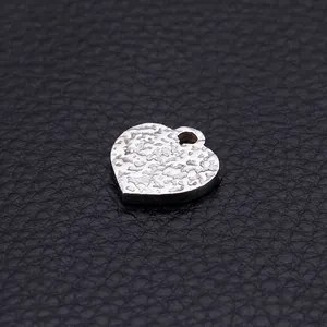Silver stainless steel heart pendant with ripple texture on black leather background