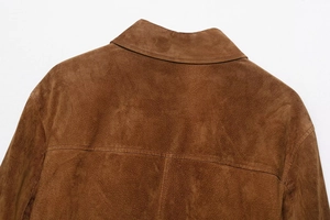 Macro detail of brown suede jacket collar and shoulder texture on white background