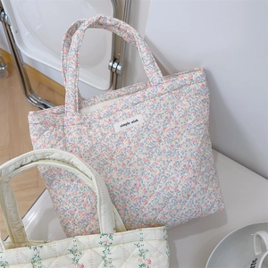 Macro view of floral quilted tote bags showing soft cotton texture and intricate stitching