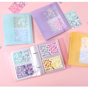 Detail of macaron-colored binders showing binder rings and transparent inner photo sleeves